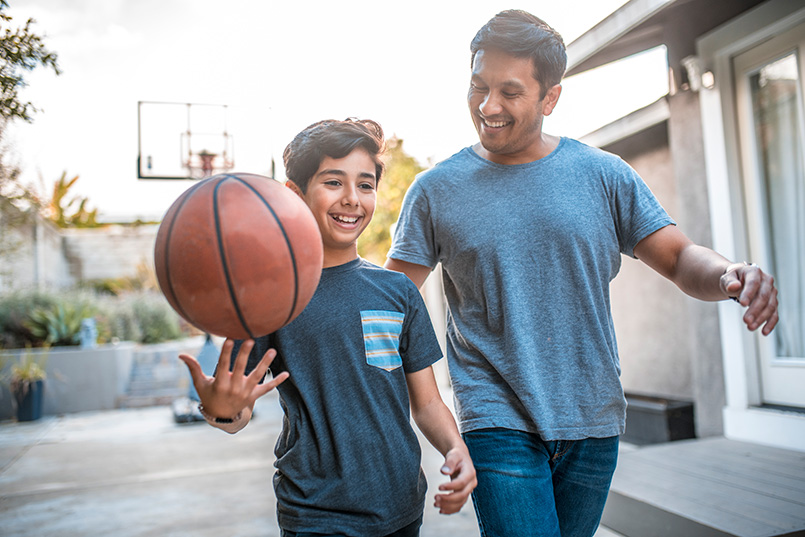 Dad and son with ADHD playing basketball together